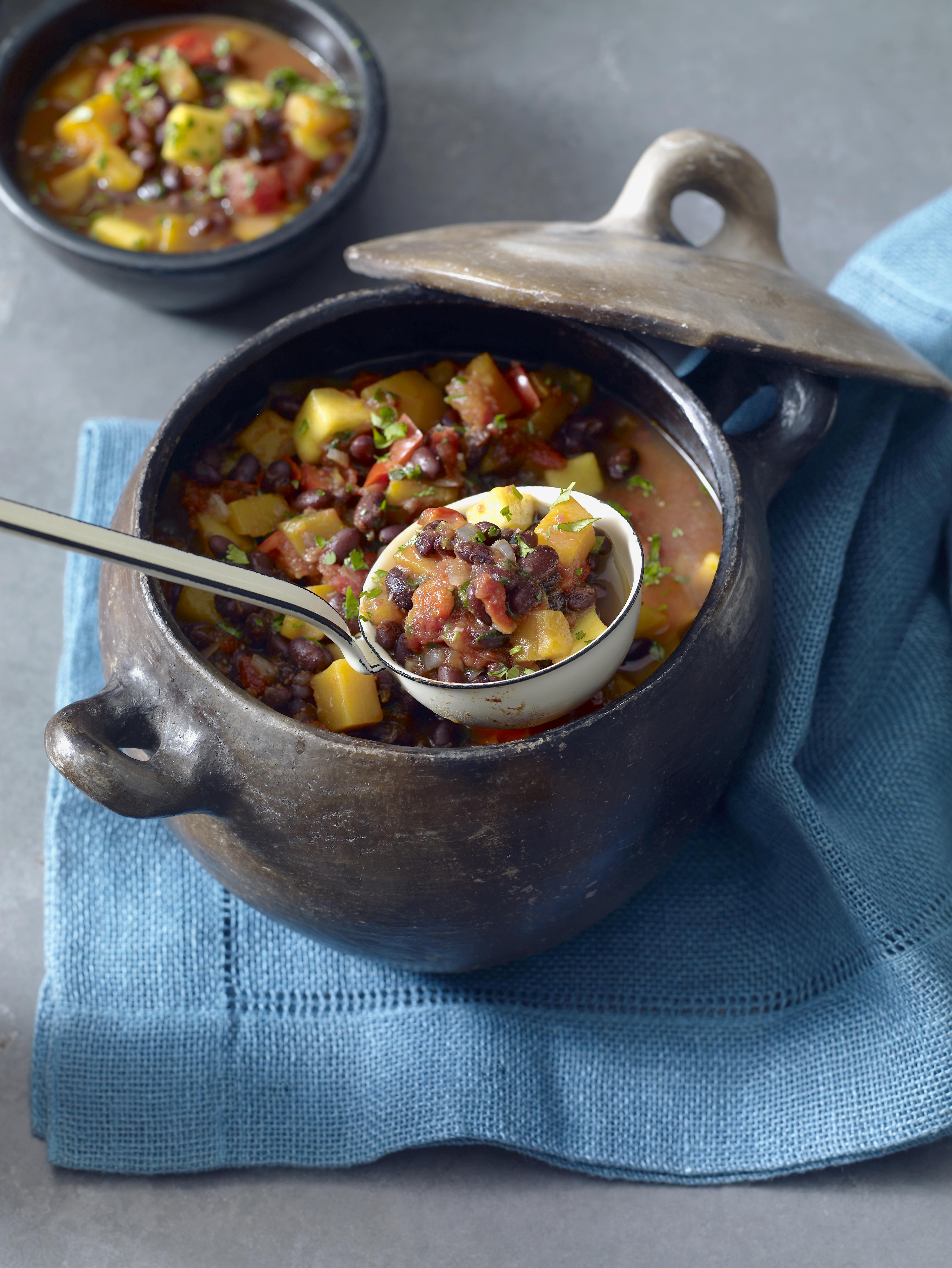Brazilian black bean and pumpkin soup served in rustic casserole dish, close-up