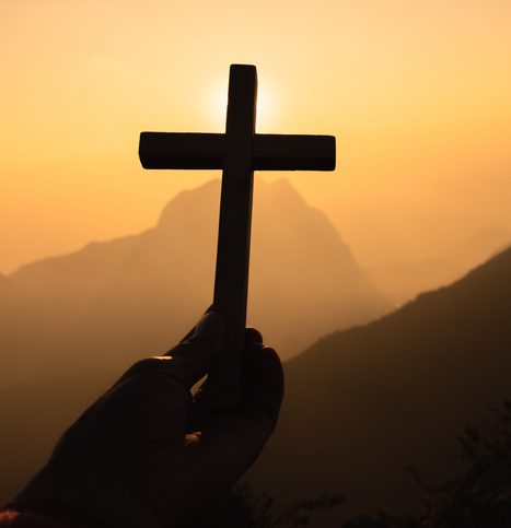 Silhouette of woman hands praying with cross in nature sunrise background, Crucifix, Symbol of Faith. Christian life crisis prayer to god.