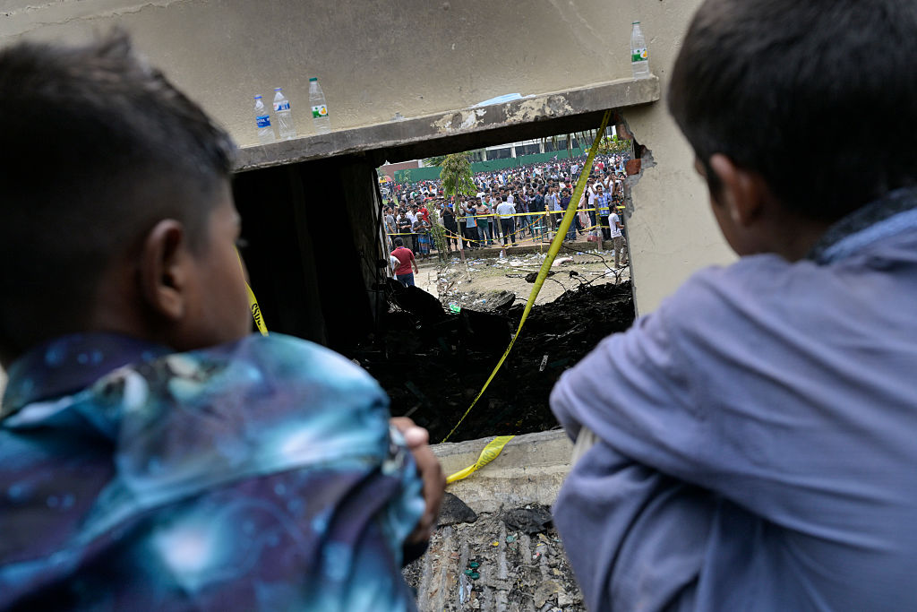 People gather at the site of a fighter jet crash at...