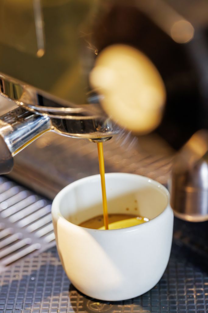 Coffee machine pouring fresh espresso into a cup