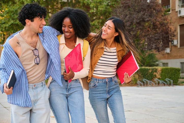 Diverse university students walking and laughing on campus
