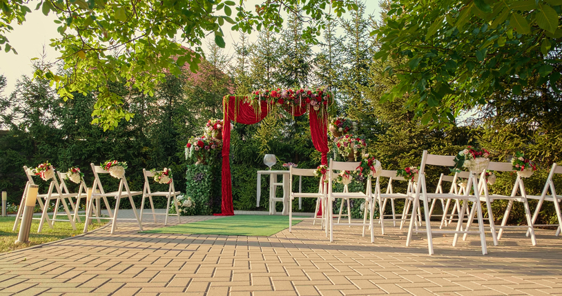 Wooden chairs and red flowers at the restaurant.